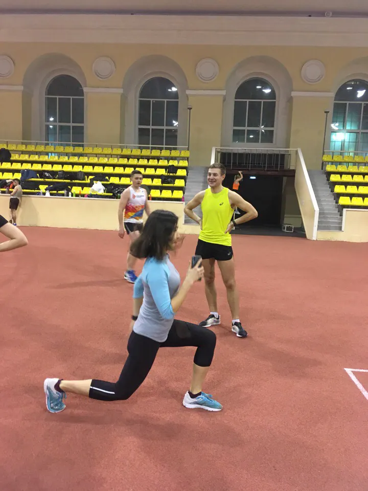Спортсменка выполняет упражнение в легкоатлетическом манеже
